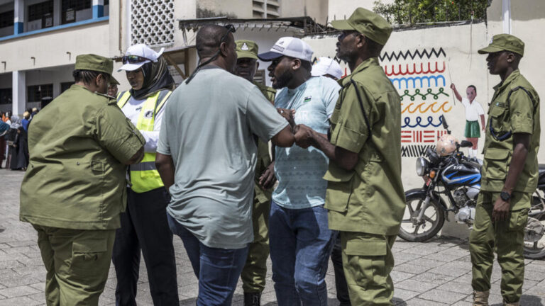 Tanzanian police officers detain a man